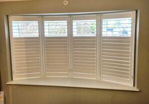 Plantation shutters installed on a bay window by Cambridge Interiors